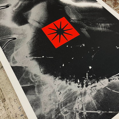 Black and white aerial view of a city with a red star symbol overlay